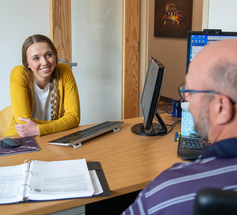 photo of a student talking with a Student Success Coach in an office