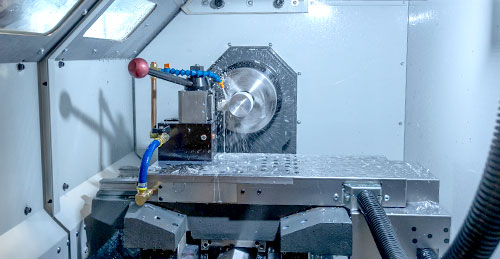 photo inside a machine with water spraying and metal shavings